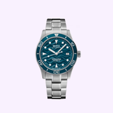 The Mido Watches Ocean Star 39 M0269071104101, a stainless steel Swiss automatic dive watch with a blue wave-pattern dial, date window, and rotating bezel, is shown against a light purple background.