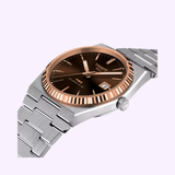 A Tissot Watches PRX Powermatic 80 Steel & 18K Gold Bezel 40mm (T9314074129100) wristwatch, featuring a brown dial, silver hour markers, fluted 18K gold bezel, and date display, shown at an angle against a light background.
