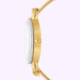 Side view of the Tory Burch Watches THE MILLER TBW6019SET in gold, featuring a white dial and gold crown, displayed against a light purple background—an elegant piece from the Tory Burch Watches women’s interchangeable watch set.