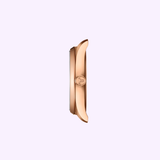 Side view of a rose gold stainless steel watch case, highlighting its slim profile, crown with engraved logo, and smooth curved edges against a plain light background—a refined detail from the Swiss Made women’s watch Tissot Watches PRX 34mm T1370101135100.