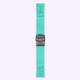 A turquoise watch strap from Luminox Watches, crafted for the Pacific Diver Limited Edition 44 mm XS.3124.N.SET Swiss Made dive watch, features raised “LUMI” and “NOX” text and a black buckle, shown vertically on a light purple background.