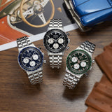 Three Seiko Watches Chronograph SSB479 models with metal bands and blue, black, and green dials sit on a wooden surface near a toy car, wallet, and vintage car photo—ideal for Seiko Watches fans in Miami.