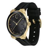 The Movado Watches 3600623 Bold Fusion men’s watch features a black round dial with gold markers, date window, and a sleek black silicone strap, set against a white background.