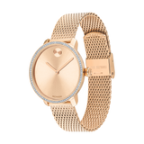 The Movado Watches 3600657 Lexor Miami women’s watch features rose gold stainless steel, a mesh band, minimalist dial with a single raised dot at 12, crystal-accented bezel, Swiss quartz movement, and secure clasp closure.