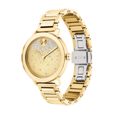 The Movado 3600705 Bold Evolution Women’s Watch by Movado Watches features a gold-tone stainless steel strap, sparkling textured dial with crystal accents, a silver clasp engraved "MOVADO BOLD," and a clean face without hour markers.