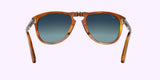 Persol PO0714SM 96/S3 54 Unisex Sunglasses by Persol Sunglasses, in brown tortoiseshell with dark gradient lenses, are displayed front-facing on a light pink background. The open arms and silver bridge hinge echo the iconic folding design.