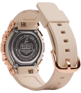 The image shows the back of a G-Shock GM-S5600PG-4 women’s watch from G-Shock Watches with a beige resin strap, rose gold accents, and engraved metal case back, available at Lexor Miami.