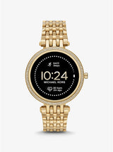 The Michael Kors Watches MKT5127V Gen 5E Darci Pave is a gold stainless steel women's smartwatch with a jeweled bezel, link bracelet, and round digital display showing time, steps, and heart rate. Powered by Wear OS.