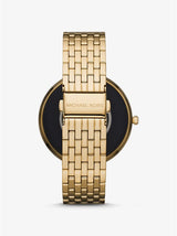 The Michael Kors MKT5127V Gen 5E Darci Pave Gold Stainless Steel Women’s Smartwatch is shown from the back, highlighting its metal link bracelet and branded clasp. The watch face remains mostly out of view.