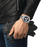 A person wearing a leather jacket and a Tissot T1316171104200 PRS 516 Chronograph Men’s Watch by Tissot Watches.
