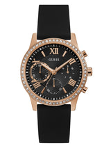 The Guess U1135L4 Solar Women’s Watch by Guess Watches features a black face, rose gold crystal-adorned case, Roman numeral markers, three subdials, black silicone strap, and three gold side buttons.