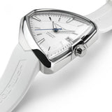 A close-up of the Hamilton H24505311 Ventura Elvis80 Auto unisex watch by Hamilton Watches, featuring a white triangular face, silver markers, date window, and a white textured silicone strap with polished silver bezel and crown.