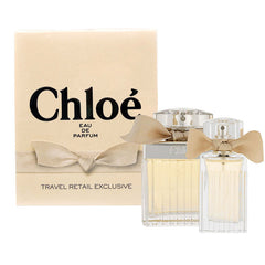 The Chloe Perfumes 2.5oz EDP + 20ML EDP Woman Parfum Set is shown with both bottles beside a cream box labeled “Chloé Eau de Parfum, Travel Retail Exclusive.”.