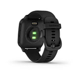 The Garmin 010-02430-00 Venu®SQ Music Edition by Garmin Watches is shown from the back, featuring a glowing green heart rate sensor and an adjustable black silicone strap with a buckle.